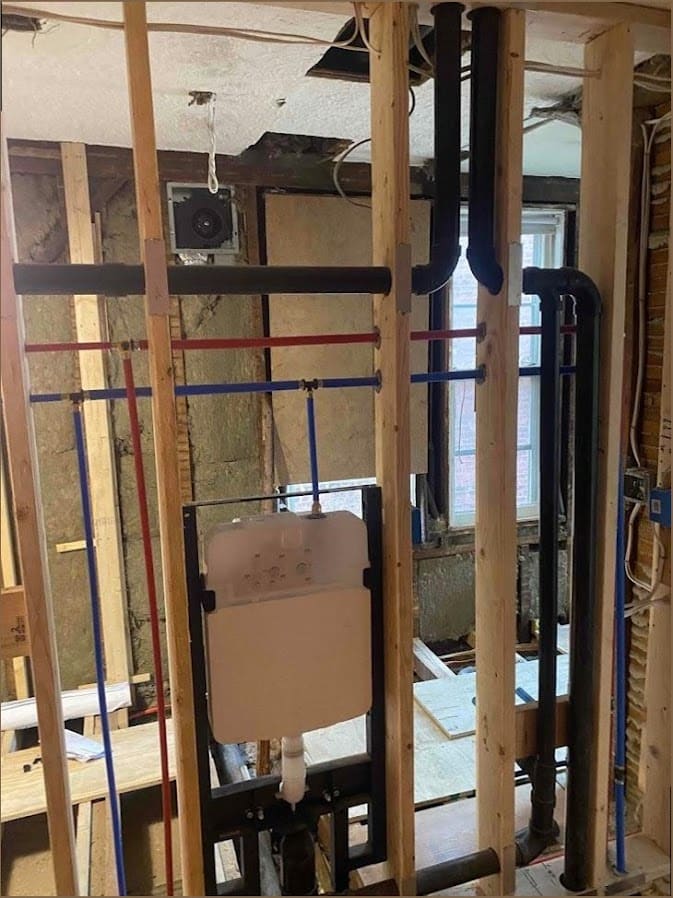 Bathroom rough-in with PEX supply lines and cast-iron stack in a Newtown, PA home by Duncan Family Plumbing