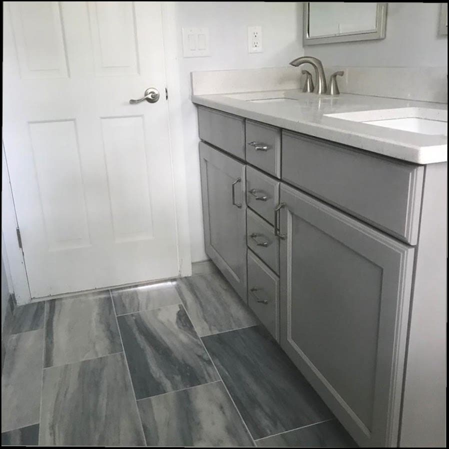 Finished bathroom vanity remodel with gray cabinets and tile flooring by Duncan Family Plumbing