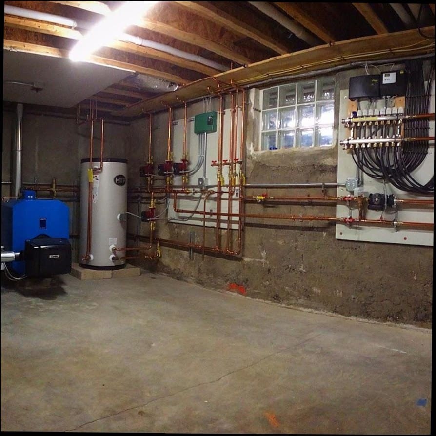 Full boiler room with HTP indirect water heater, oil boiler, copper piping, and radiant manifold installed by Duncan Family Plumbing