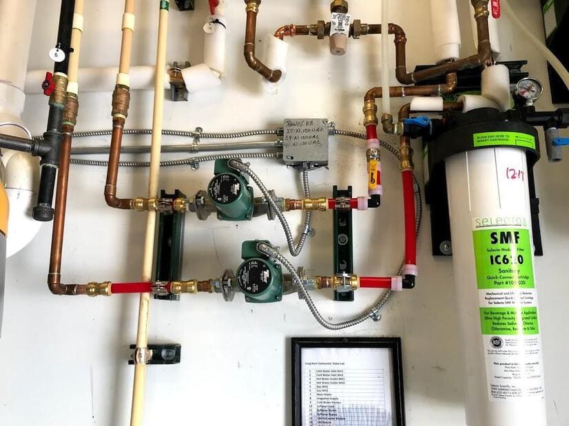 Mechanical room with copper piping, pumps, and water filtration serviced by Duncan Family Plumbing near the Penndel/Neshaminy corridor
