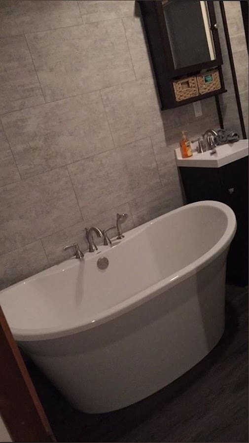 Freestanding soaking tub with tile surround installed by Duncan Family Plumbing