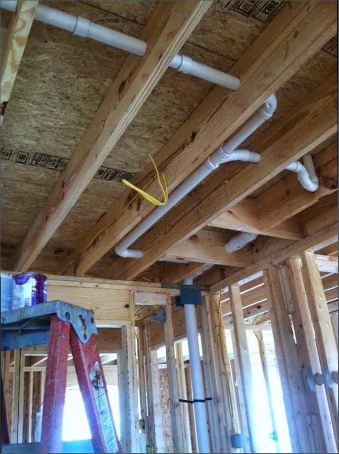 Overhead PVC drain and vent rough-in in a newer-construction home, similar to the build style throughout Newtown Grant