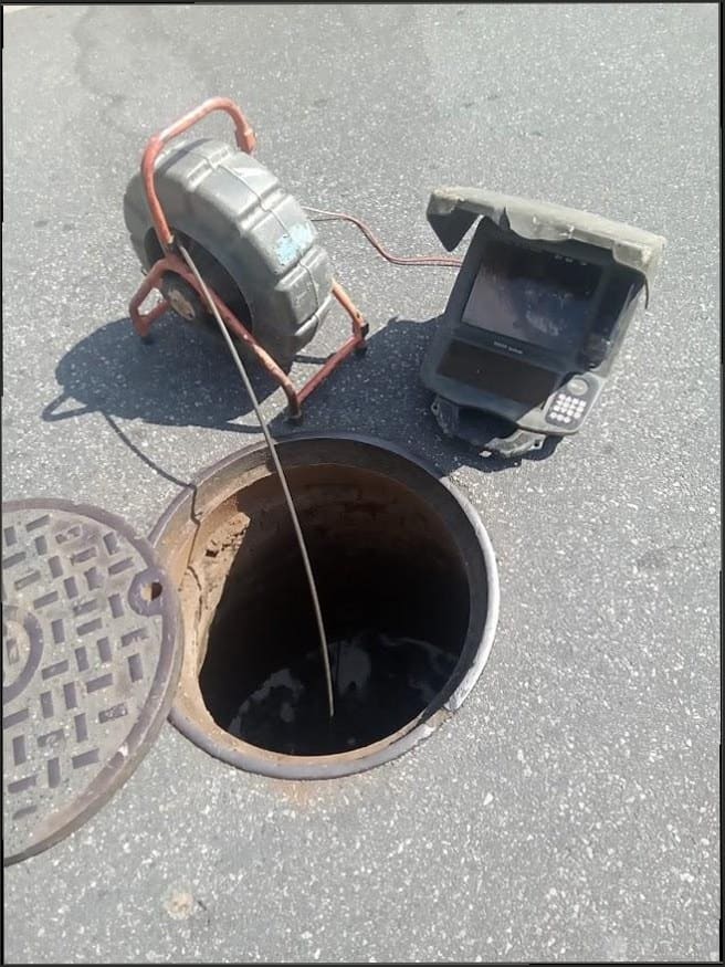 Sewer camera inspection equipment and monitor at an open manhole used by Duncan Family Plumbing