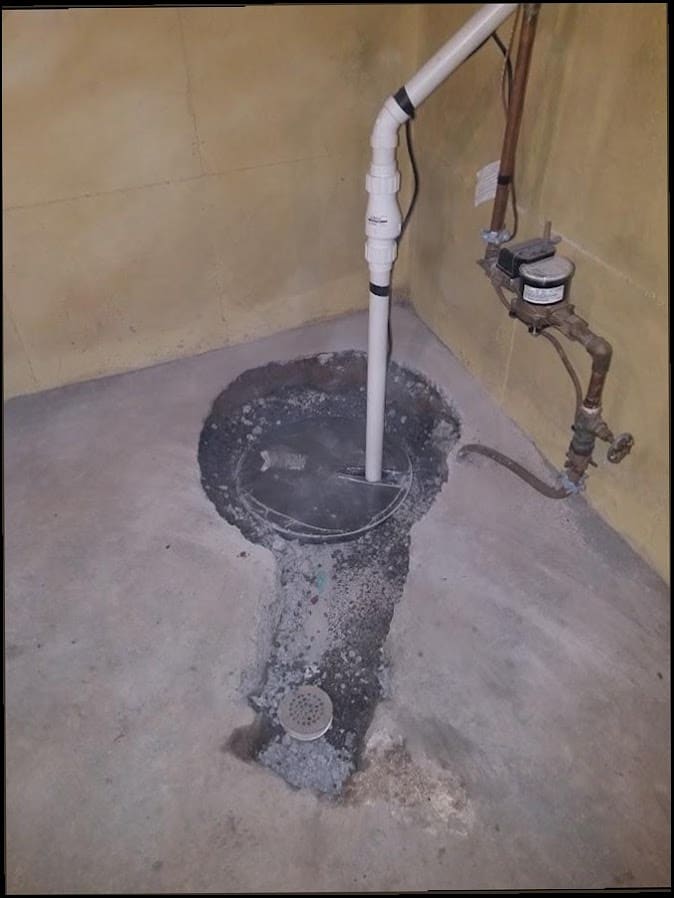 Sump pump installed in a basement pit, the kind of flood-prevention work common in riverfront Yardley homes