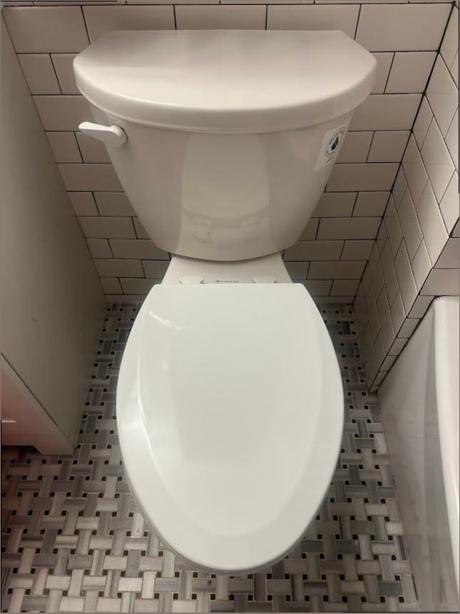 Newly installed toilet on a tiled bathroom floor, the kind of fixture replacement common in aging Holland homes