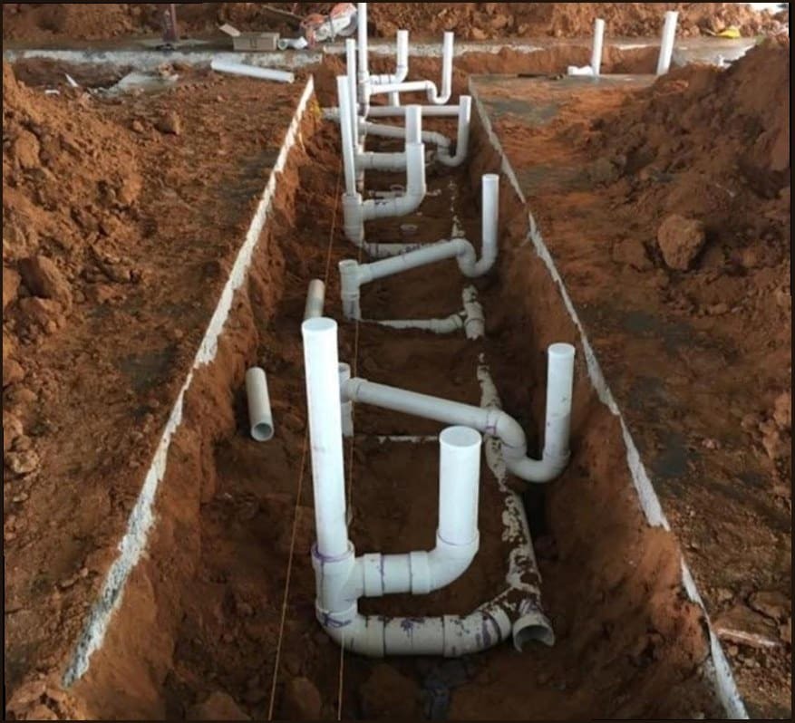 Underground drain line exposed and repaired beneath a concrete slab, the kind of hidden-pipe work common in 1950s Fairless Hills tract homes
