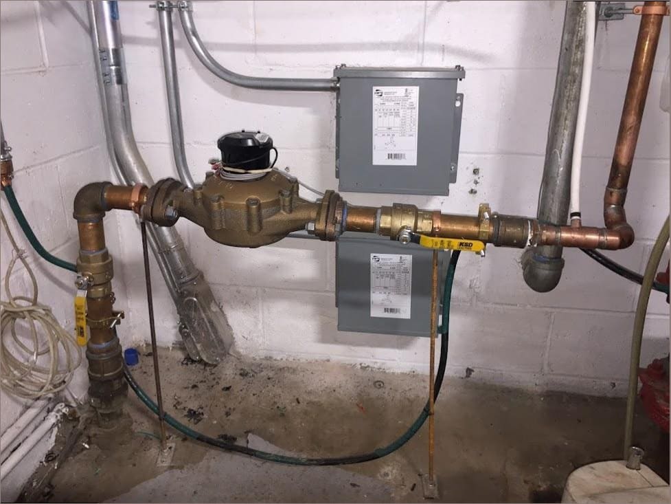 Water meter and copper supply piping in a Bucks County basement — serviced by Duncan Family Plumbing